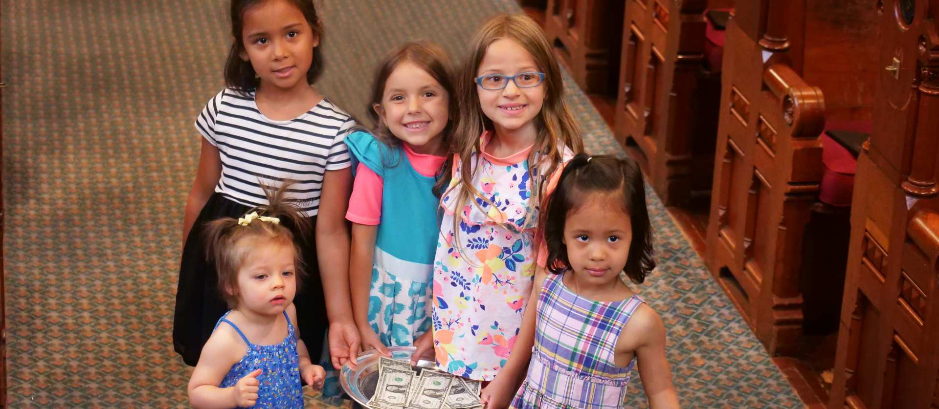 kids holding the offering plate